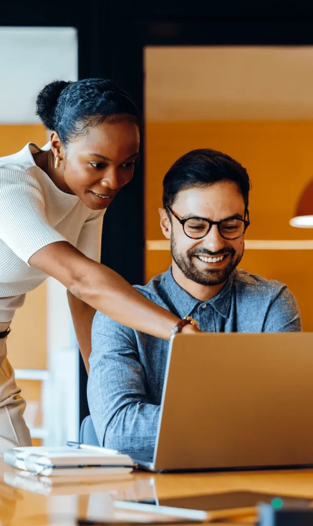 Two people looking at a computer in an office