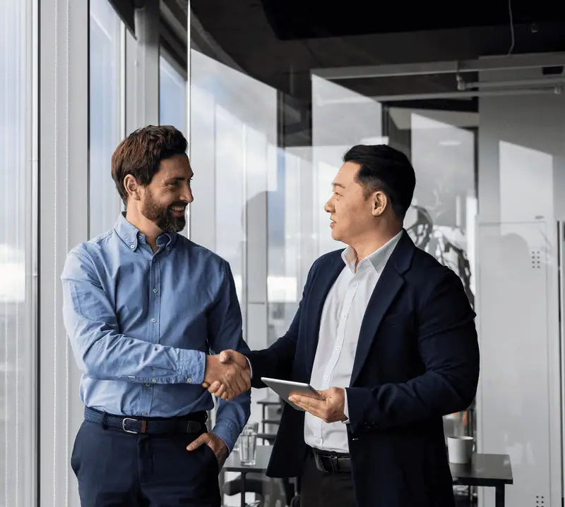 Two business men shaking hands in an office